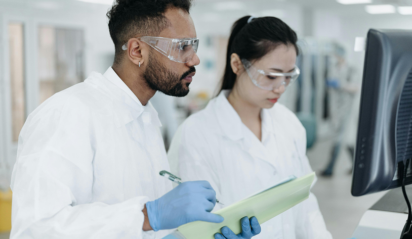 Two lab technicians studying a computer screen