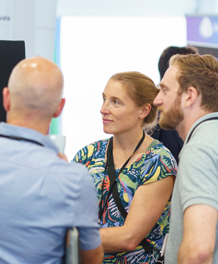 Two men and a woman networking at a hydrogen event