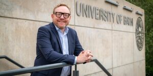 Photo of Prof Phil Taylor smiling in front of University of Bath sign.