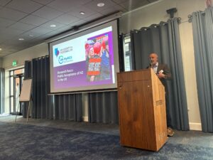 Professor Chris Jones, Social Theme Lead, standing at a podium and presenting on the topic of ‘Social Acceptance of Hydrogen in the UK’, at the Flame Days 2026 event